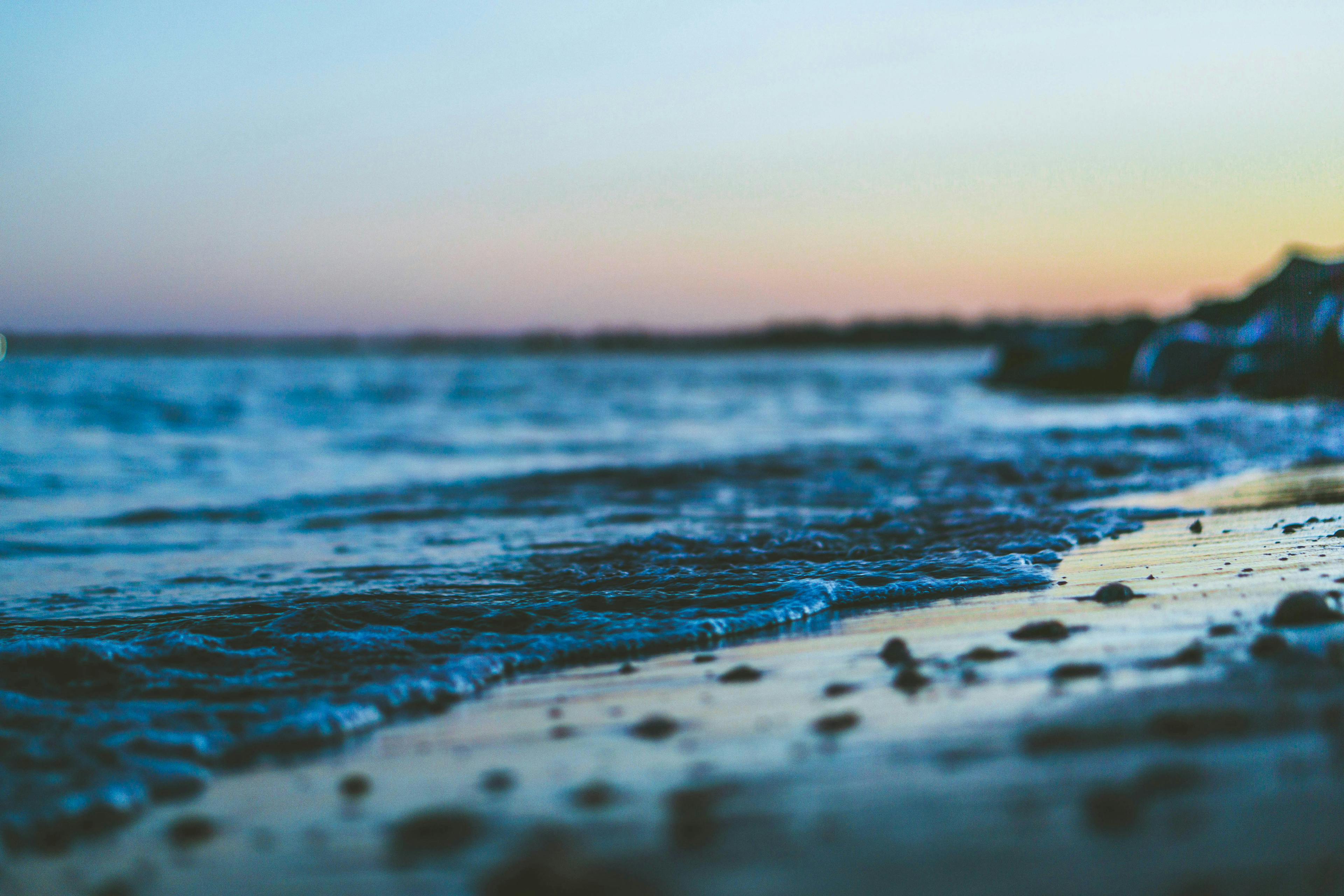 Photograph of a shoreline at sunset. Photo by Derek Story via Unsplash.